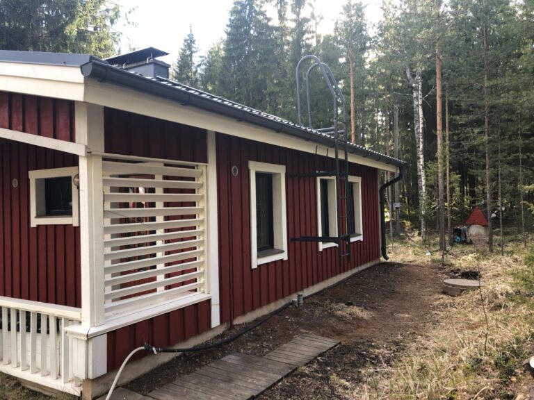 Punamullattu mökki sivusta
